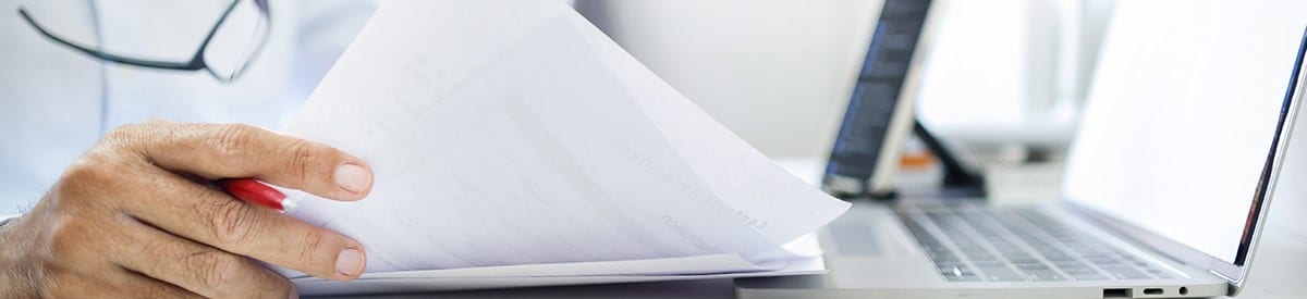 primer plano de la mano de una persona sosteniendo una pila de papeles